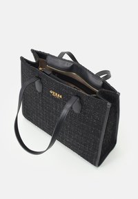 Czarna torba tote o teksturowanej powierzchni z gładkimi skórzanymi akcentami w odcieniu czarnym, złotym logo, dwoma uchwytami u góry oraz zamykaną komorą wewnętrzną.