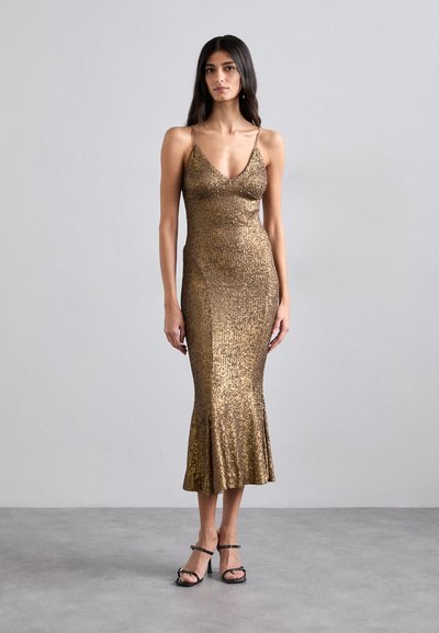 Guld palietmikrobebdress med tætsiddende skørt og flagrende kant. Har tynde stropper og en V-udskæring. Glat tekstur med en glitrende overflade.
