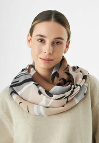Écharpe infini beige avec des motifs abstraits noirs et gris ; texture lisse et tissu doux ; tombe lâchement autour du cou.