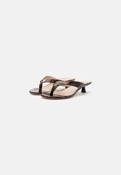 Sandales tongs à talon bas, motif écaille de tortue marron, bout ouvert et finition brillante élégante sur fond neutre.