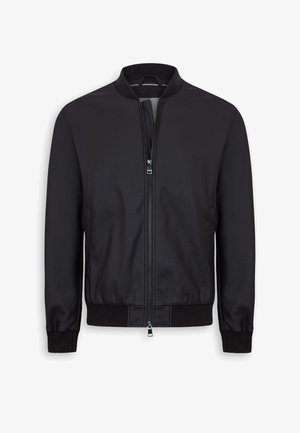 Schwarze Bomberjacke mit Frontreißverschluss, geripptem Kragen, Bündchen und Bund, aufgehängt an einem schwarzen Kleiderbügel.