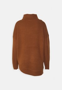 Brązowy sweter z dzianiny z wysokim kołnierzem, prążkowaną fakturą, oversize'owym krojem i nieco dłuższym tylnym końcem. Brak widocznych elementów metalowych lub wzorów.