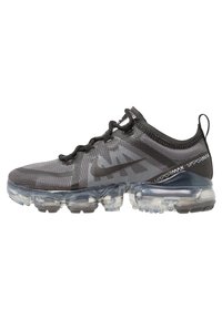 Scarpa da ginnastica nera in rete con suola trasparente a bolla d'aria, con motivo testurizzato sulla parte superiore e lacci neri; logo Nike sul lato.