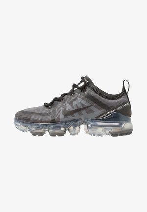 Chaussure de sport en mesh noir avec semelle à bulle d'air transparente, présentant un motif texturé sur le dessus et des lacets noirs ; logo Nike sur le côté.
