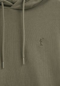 Felpa verde oliva in morbido tessuto a maglia, con tasca a marsupio e lacci. Logo ricamato di un golfista sul lato sinistro del petto.