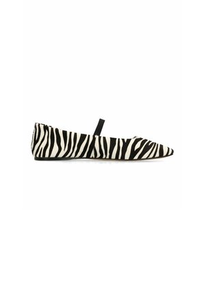 Chaussure plate à bout pointu avec imprimé zèbre noir et blanc et une seule bride noire sur le dessus.