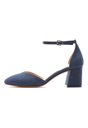 Chaussure en daim bleu à petit talon carré avec bout pointu fermé et bride de cheville réglable avec petite boucle.