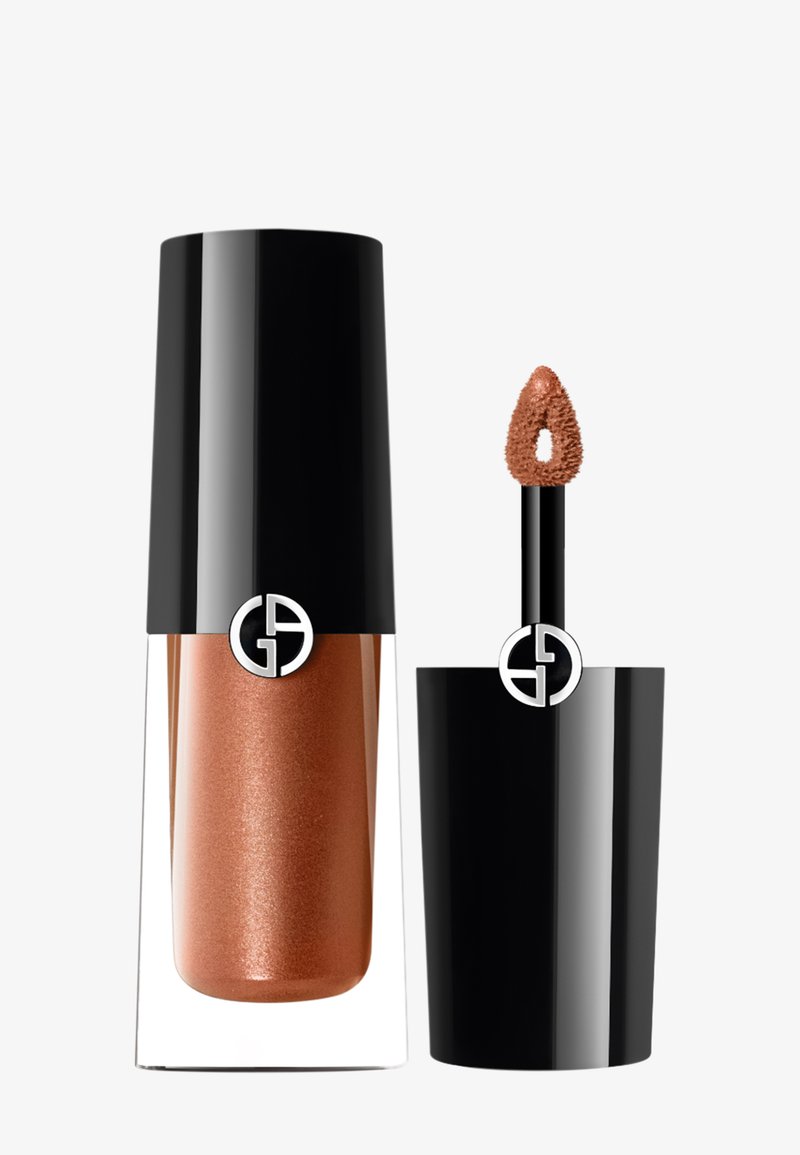 Vloeibare lipgloss in een doorzichtige container, met een zwarte deksel en een applicator met een doe-foot. De gloss is brons met shimmer. Logo op de dop.