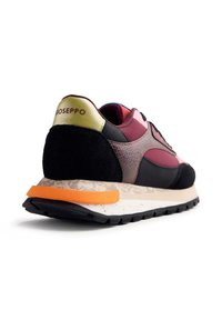 Zapatilla negra y burdeos con un upper de tela texturizada, detalles en ante, una entresuela naranja y una lengüeta en el talón de color amarillo contrastante.