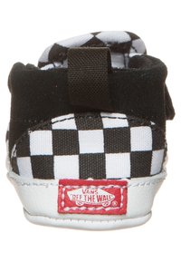 Černo-bílé kachličkové plátěné boty s měkkým textilním svrškem, elastickým páskem a gumovou podešví. Červené logo "Vans Off The Wall" na patě.