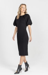 Czarna dzianinowa sukienka z bufiastymi rękawami, o długości do kolan, dopasowany fason. Noszona z czarnymi botkami za kostkę z złotymi akcentami.