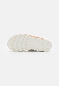 White sneaker sole with textured patterns; features a slight curve and ridged design for traction; brand name "Gabor" visible on sole.