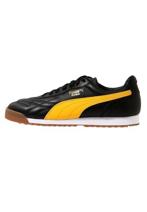 Basket Puma Roma noire et jaune avec semelle en gomme, logo latéral et lacets, vue du côté extérieur sur fond blanc.