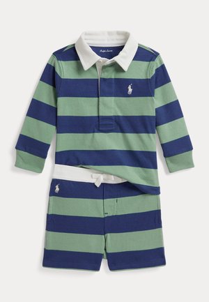 Ensemble maillot de rugby à manches longues et short avec larges rayures horizontales bleu marine et vertes, col blanc et broderie du logo sur la poitrine et le short.