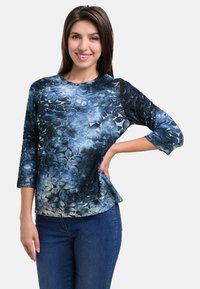 Blue floral-patterned long-sleeve top with a round neckline and relaxed fit, made from soft fabric with smooth texture.