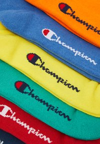 Fargerike bomullssokker stablet i en haug, med blå, gul, grønn, rød, oransje og svarte detaljer, med "Champion"-logoen brodert fremtredende.