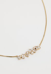 Gold-tone necklace featuring alternating clear rhinestones in various rectangular and round shapes, with a fine chain design.