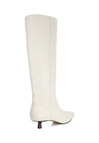 Knee-high, white leather boots with a pointed toe, low stacked heel, and smooth texture. Side seam detailing enhances the design.