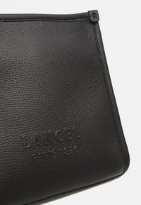 Borsa in pelle nera con superficie testurizzata, logo "Lancel" impresso e una forma rettangolare elegante con dettagli di cucitura minimi.