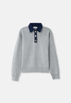 Grå hettegenser med en mørkeblå denimkrage, tre gullknapper og ribbede mansjetter. Myk tekstur med et uformelt design.