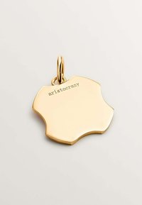 Colgante de oro con forma ondulada, que presenta una superficie pulida y la grabación "aristocrazy" en un lado.