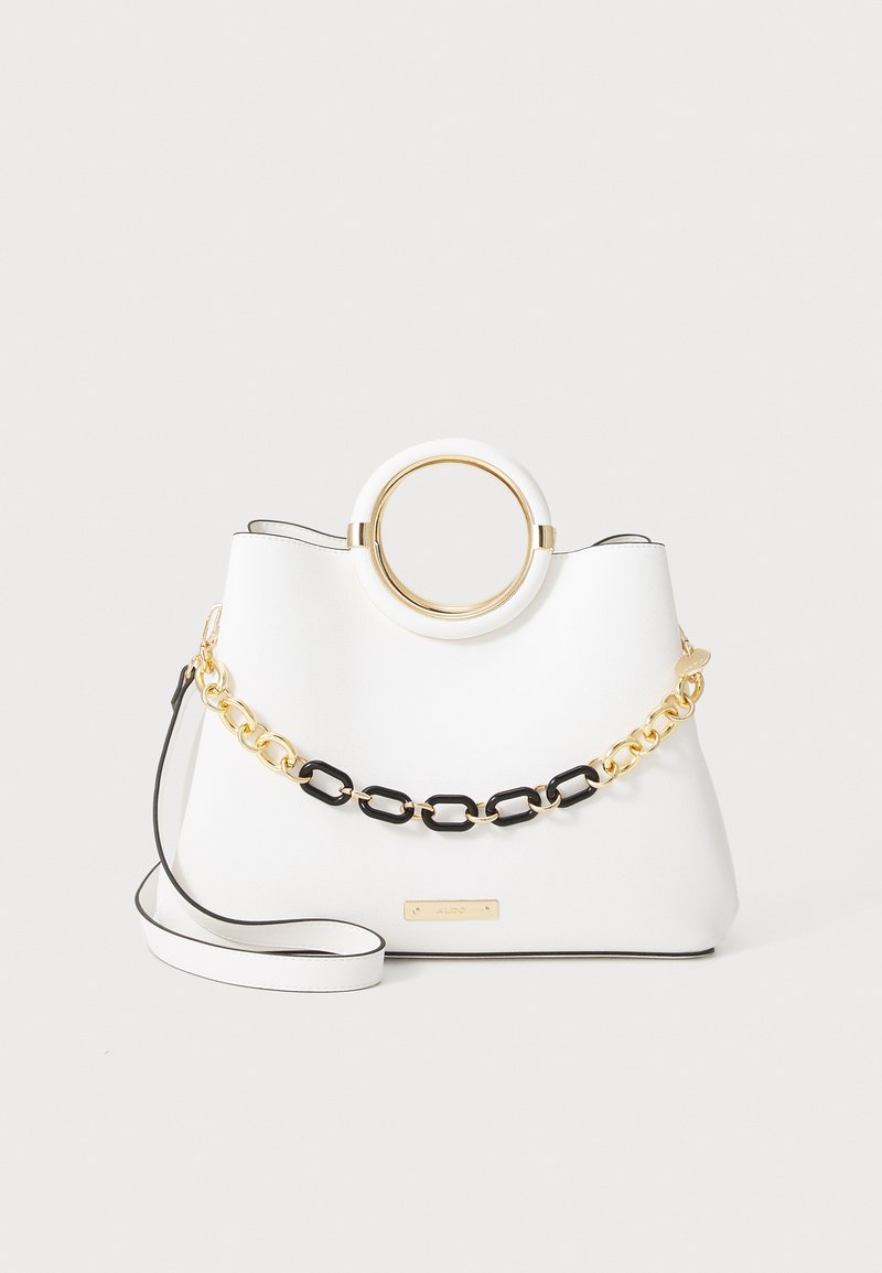 Valge faux nahast käekott ringikujulise kuldse sangaga, mustade ja kuldsete ahelate aktsentidega ning eemaldatava rihmaga. Tekstureeritud pind.