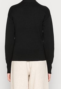 Czarny dzianinowy sweter z wysokim kołnierzem oraz ściągaczami na rękawach i dolnym brzegu. Prosty, dopasowany fason, wykonany z miękkiego materiału, odpowiedni do nakładania warstw.