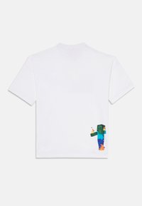 Camiseta blanca de manga corta con un personaje verde pixelado que lleva pantalones azules y un objeto que arde impreso en la parte baja de la espalda.