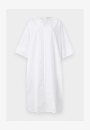 Χαλαρό λευκό φόρεμα μέχρι το γόνατο με φαρδιά μανίκια στα τρία τέταρτα και V-λαιμόκοψη, εμφανιζόμενο σε μονόχρωμο φόντο.