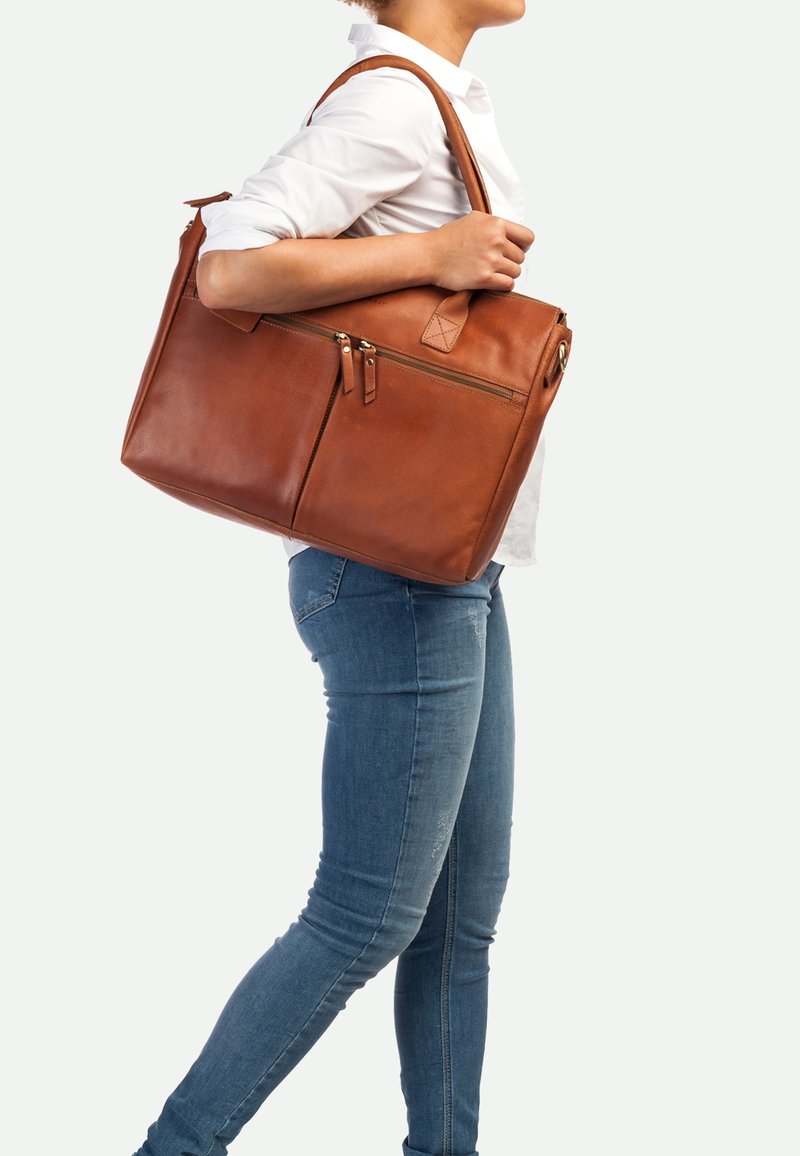 Bruine leren totebag met twee ritszakken en een lange handgreep. Gladde textuur, rechte vorm, met een diamantaccentstuk.