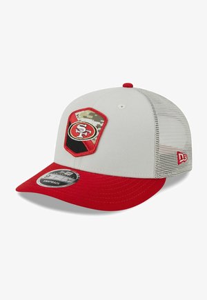 Weißer Hut mit roter Spitze, Netz-Rückseite und einem gestickten SF-Logo in Schwarz und Rot auf einem sechseckigen Patch mit Camouflage-Hintergrund.