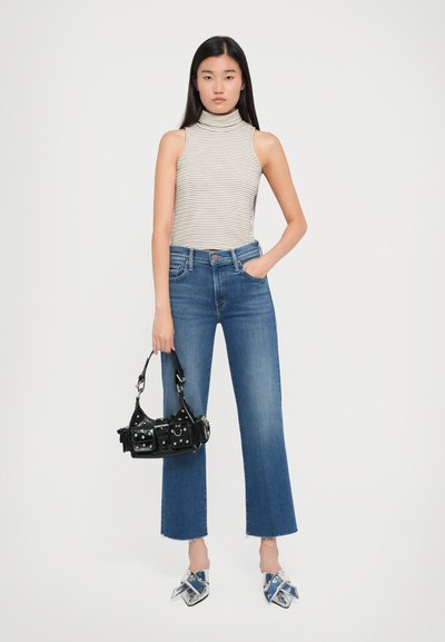 Top senza maniche a righe, jeans a zampa d'elefante in denim blu con vita alta, borsa nera con hardware argentato e mule blu con motivo e fiocchi.