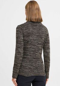 Strikkegenser i mørkegrå med lyse flekker, med høy hals og lange ermer. Strukturert passform med ribbestrikkede detaljer på nederkant og mansjetter.