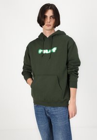 Hanorac de culoare verde închis, cu buzunar frontal și glugă cu șnur ajustabil. Prezintă o grafică reflectorizantă albă și verde deschis pe piept.