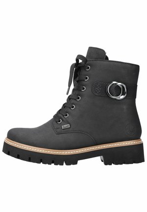 Bottine noire avec une tige en cuir texturé, bout rond, devant à lacets, accent métallique circulaire et semelle en caoutchouc épaisse avec couture contrastée.