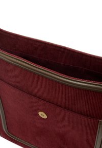 Burgundy kordfluvsåse med släta läderkanter, framficka med en guldtonad knapp och en mjuk tyginredning.