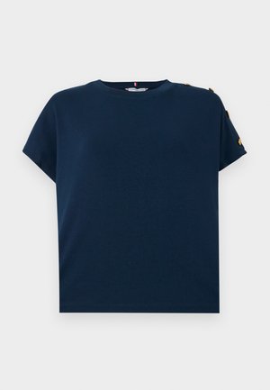 T-shirt bleu marine en coton doux, avec un col rond, des manches courtes et des accents en bouton doré sur l'épaule.