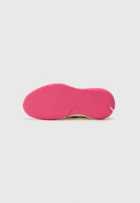 Semelle de chaussure avec un fond en caoutchouc rose vif, d'une texture lisse et d'une légère courbure, entourée d'un bord jaune contrastant.