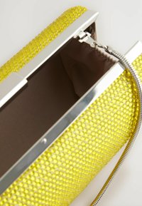 Metallic sølv clutch med gul tekstureret ydre og en glat brun indvendig. Har en kædedesign og lås lukning.