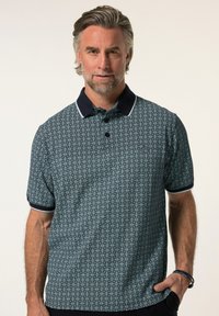 Polo tričko s krátkým rukávem v námořnické modři s geometrickým bílým vzorem, s kontrastním límečkem a knoflíky, vyrobené z prodyšného materiálu.