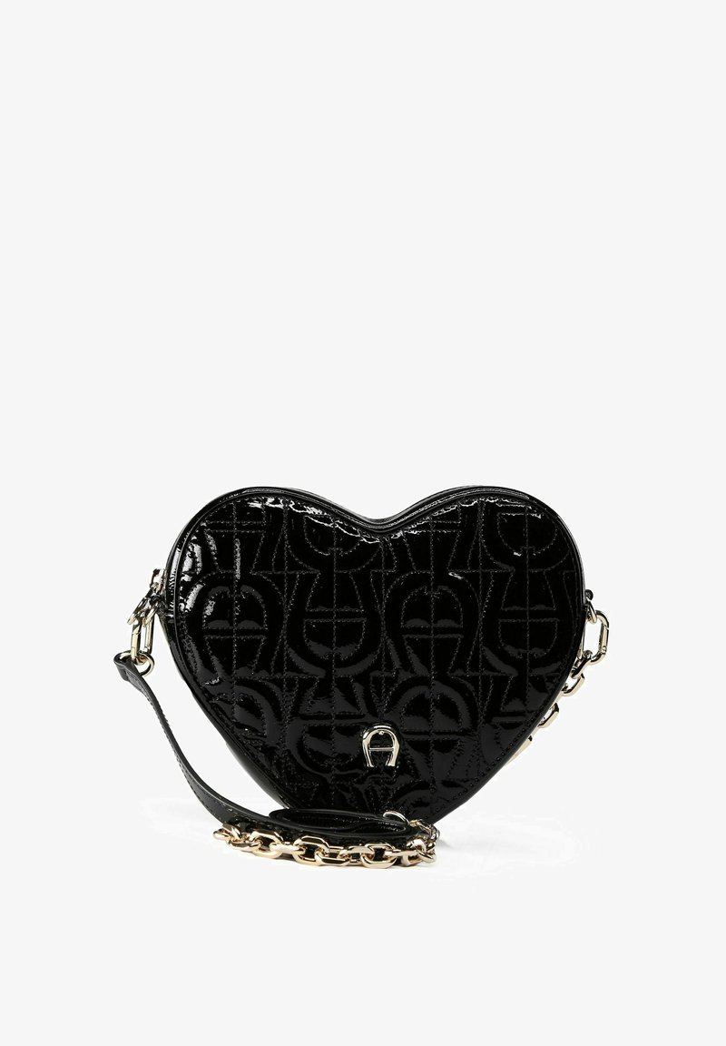 Bolso negro en forma de corazón hecho de charol, con un patrón de logotipo texturizado. Cuenta con una correa de cadena desmontable y detalles lisos.
