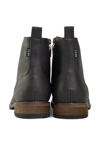 Brown vegan leather ankle boots with two side zippers, a textured finish, and a light brown wooden heel.