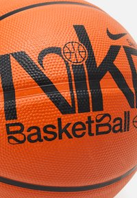 Pallone da basket arancione con superficie texturizzata, logo "Nike" nero, grafica circolare e testo in grassetto "BasketBall" con una striscia nera liscia.
