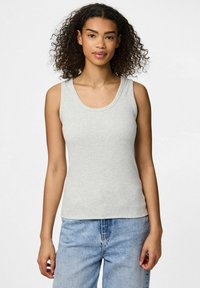 Hellgraues Tanktop mit Rundhalsausschnitt, gerippter Textur und Schulterträgern, kombiniert mit blauen Jeans. Einfaches und figurbetontes Design.