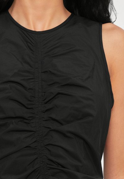 Black sleeveless top featuring front ruching details, smooth fabric texture, and a round neckline. Minimalist design with subtle accents.