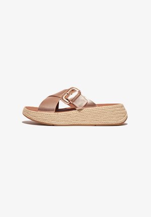 Rose gold slide sandals with a wide crossover strap and a metallic buckle. Features a braided jute platform sole for added height.
