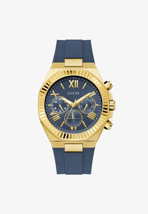 Reloj de pulsera Guess en oro y azul con correa de silicona azul, números romanos y tres subesferas que muestran funciones de 24 horas, día y fecha.