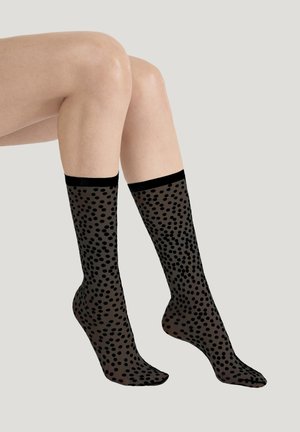 Zwarte kniehoge sokken gemaakt van doorschijnend materiaal met een gevlekt patroon. De bovenkant heeft een effen zwarte band. Soepele textuur en lichtgewicht ontwerp.