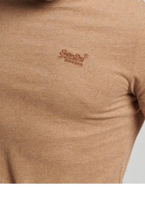 Tissu marron clair avec petit logo SuperDry brodé et caractères japonais sur la partie supérieure de la poitrine.