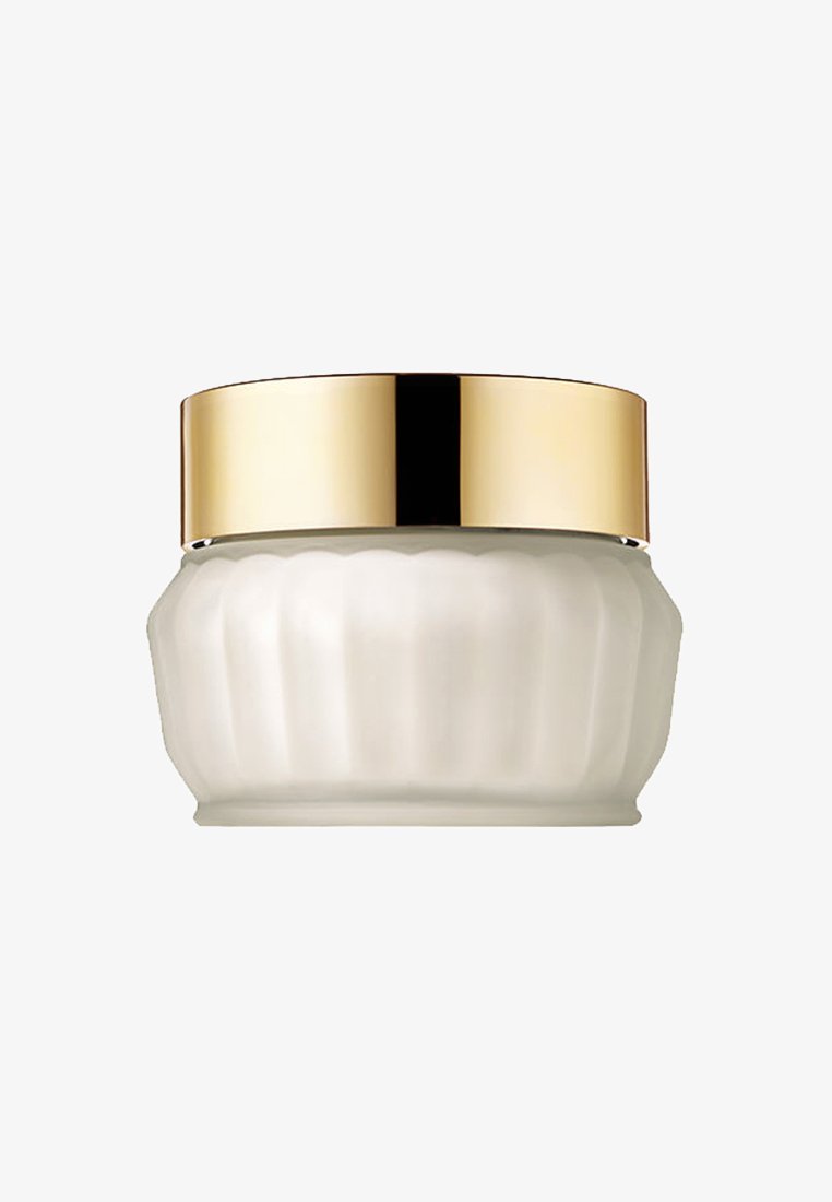 Biały szklany słoiczek na krem o ryflowanej powierzchni i gładkiej złotej pokrywce. Słoiczek ma zaokrąglony kształt, idealny do produktów kosmetycznych lub pielęgnacyjnych.